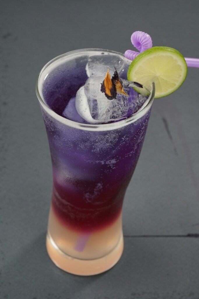 Layered purple and pink iced drink with lime
